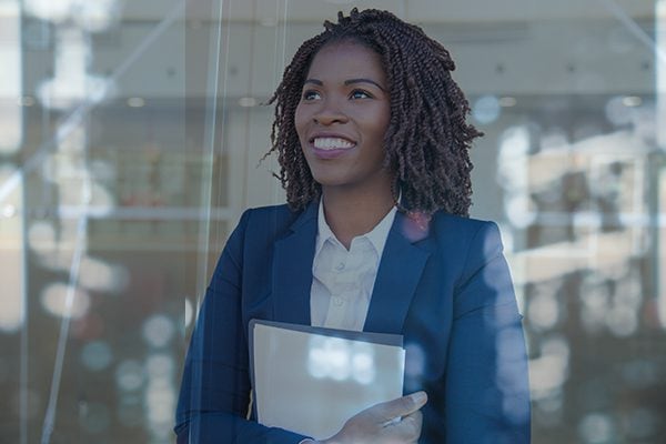 smiling woman looking hopeful holding file
