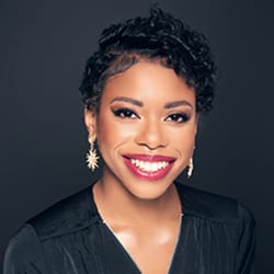 Beaonca Ward headshot photo, smiling woman with short dark hair and dark top in front of a dark background