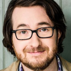 Robert Boesel headshot photo, dark haired man with glasses collared shirt and jacket smiling