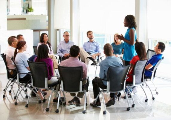 coach speaking in group coaching circle