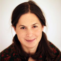 Julia Davis headshot photo, dark haired woman with a pony tail and black red top smiling
