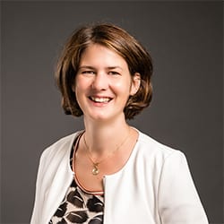 Dominique Munz PCC headshot photo, smiling woman with short brown hair
