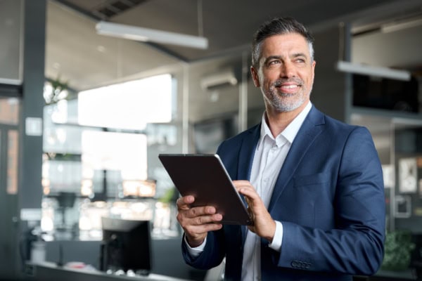 man holding a tablet standing in an office