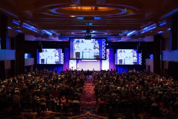 A zoomed-out image of attendees gathered for the ICF Converge 2017 conference welcome in Washington, D.C. The ICF CEO and Board Chair are on stage addressing the crowd.