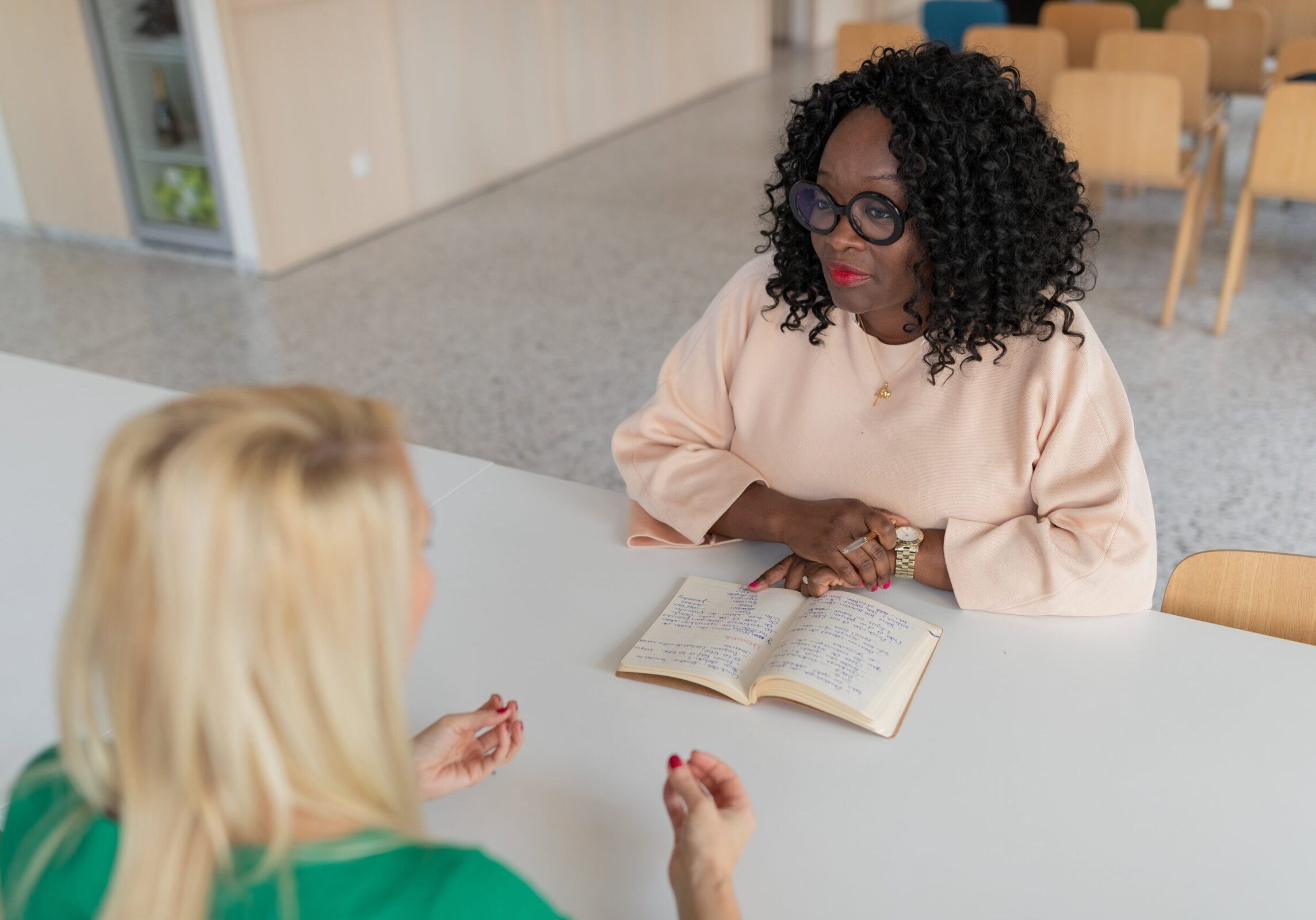 Woman attentively listening during a coaching session with natural light coming through a window.