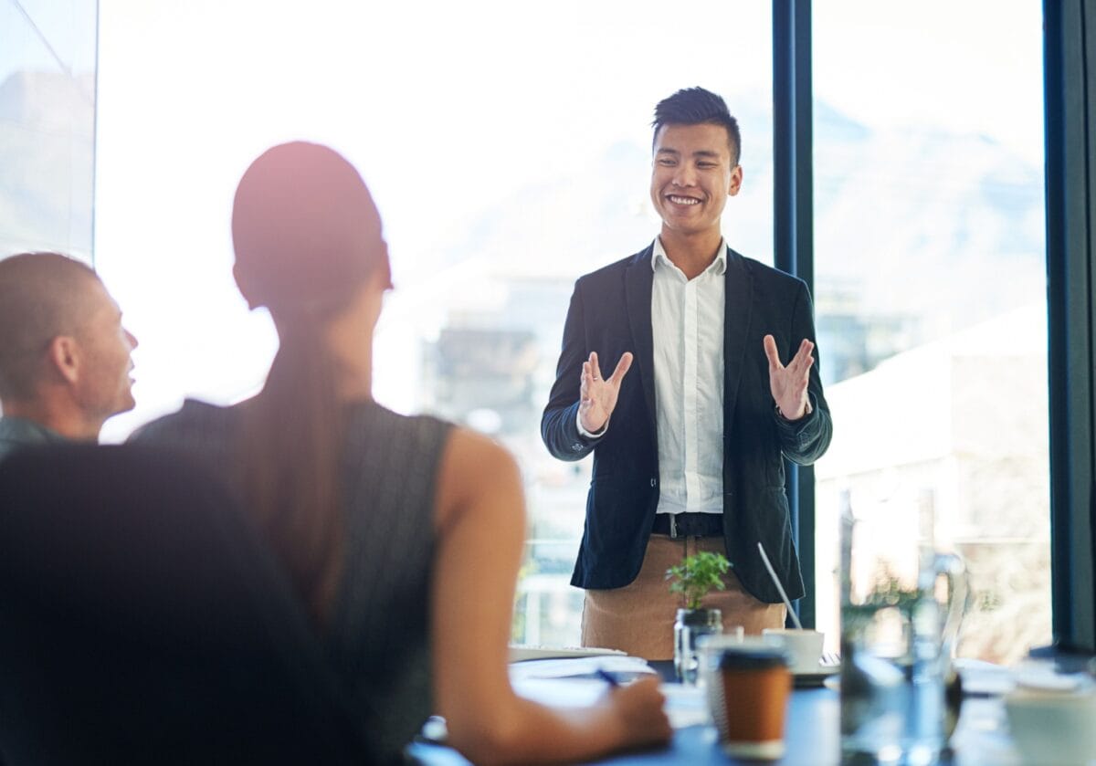 Young professional presenting a proposal during a business meeting about attending a coaching conference.