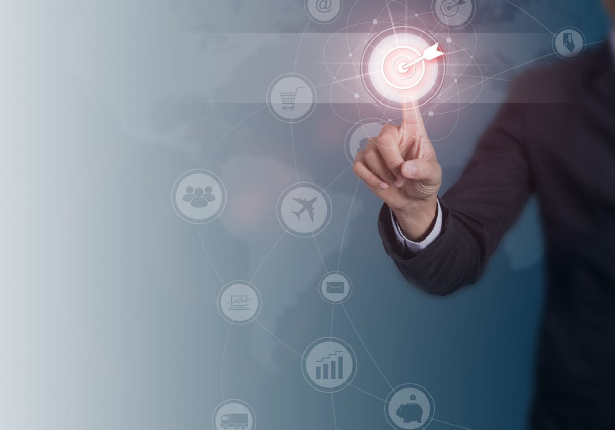 A man in a business suit selects a glowing target icon with his finger, symbolizing goal setting.
