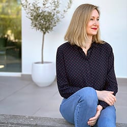 Kate Greenslade PCC headshot photo, blond woman smiling sitting outside