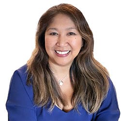 Meriflor Toneatto MCC headshot photo, smiling woman with blue top and brown hair