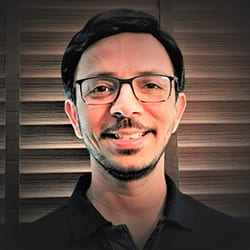 Mukul Dhawan ACC headshot photo, man smiling with glasses and dark hair