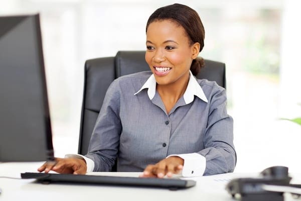 female coach sitting at a desk working on a computer
