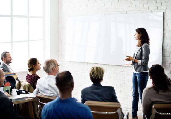 coach speaking to a room of people listening