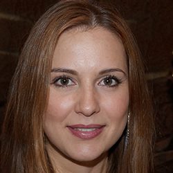 Roseanne James headshot photo, brown haired woman smiling