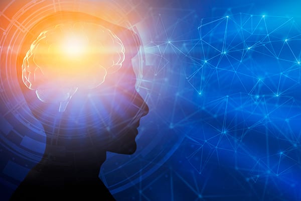silhouette of a mans head with an over lay of a lighted brain and connected dots