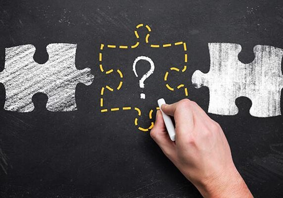 chalkboard drawings of puzzle pieces with the middle in a dotted yellow outline with a question mark in the middle