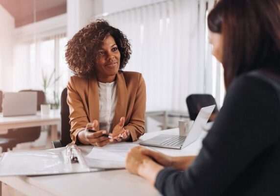 coach listening with hands open on a table while a client speaks