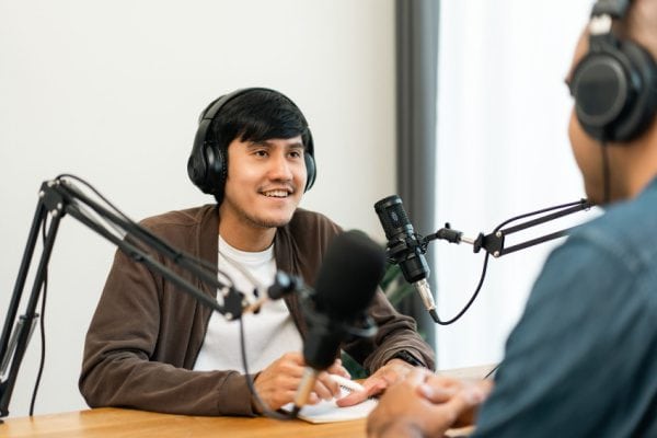 two men speaking and recoding audio with microphones