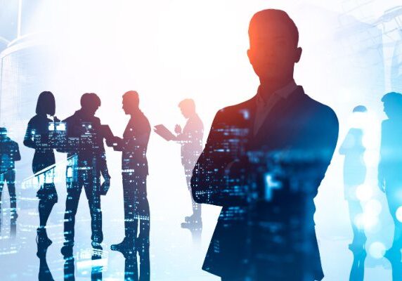 silhouettes of people working in various groups with code reflecting off of them