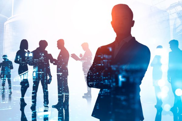 silhouettes of people working in various groups with code reflecting off of them