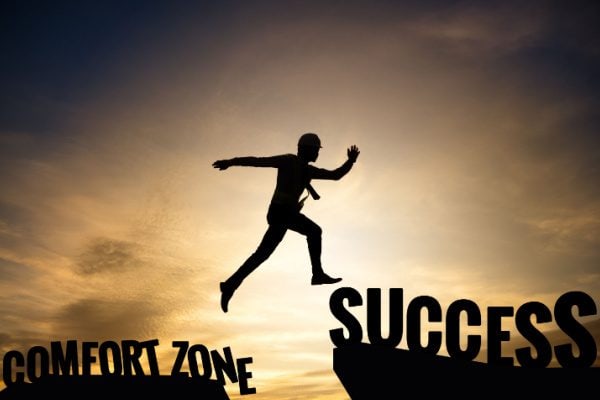 person leaping from comfort zone to success