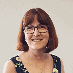 Cheryl Robinson PCC headshot photo, red haired woman with glasses and floral top smiling