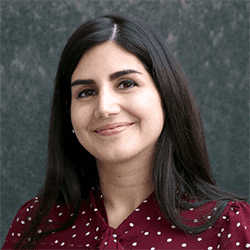 Sonia Abdulbaki headshot photo, smiling woman with dark hair and a red top in front of gray background