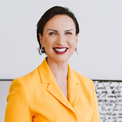 Magda Snowden PCC headshot photo, woman with short dark hair and bright yellow blazer smiling
